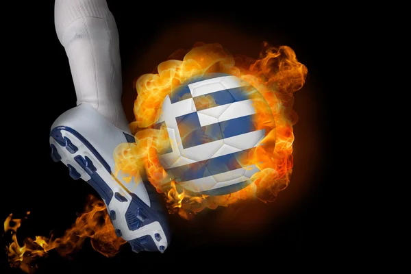 Футболист пинает горящий мяч с флагом Греции — стоковое фото