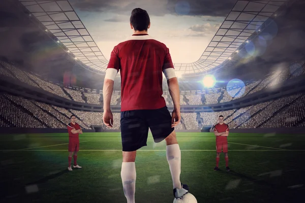 Jugador de fútbol en rojo con bola frente a la oposición — Foto de Stock