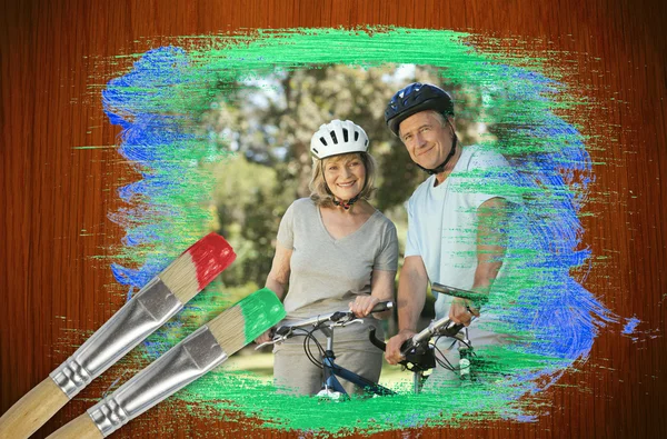 Senior couple on bikes in the park — Stock Photo, Image