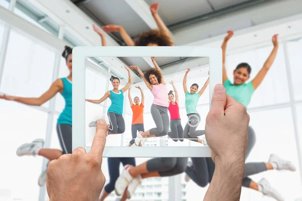 Hand holding tablet pc showing fitness class — Stock Photo, Image