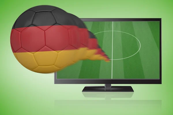 Imagem composta de futebol em cores alemãs voando para fora da tv — Fotografia de Stock