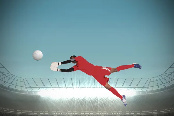 Composite image of goalkeeper in red making a save — Stock Photo, Image