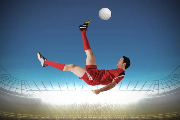 Sammansatt bild av fotbollsspelare i röda sparkar — Stockfoto