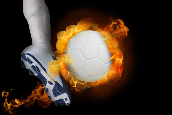 Football player kicking flaming ball — Stock Photo, Image