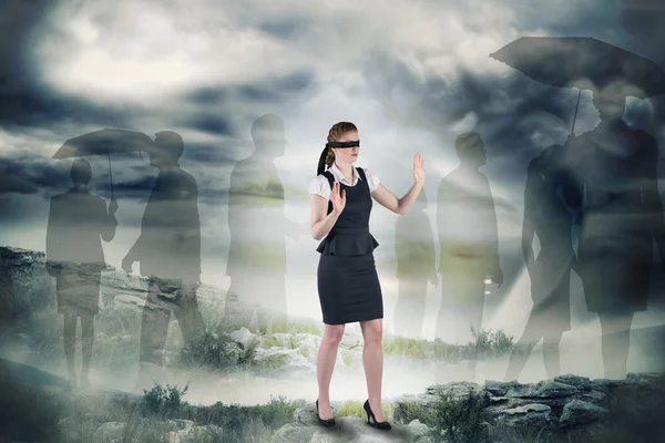 Samengestelde afbeelding van roodharige zakenvrouw in een blinddoek — Stockfoto