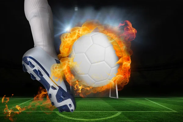 Football player kicking flaming ball — Stock Photo, Image