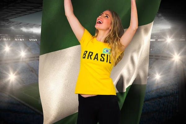 Excited football fan in brasil tshirt holding flag — Stock Photo, Image