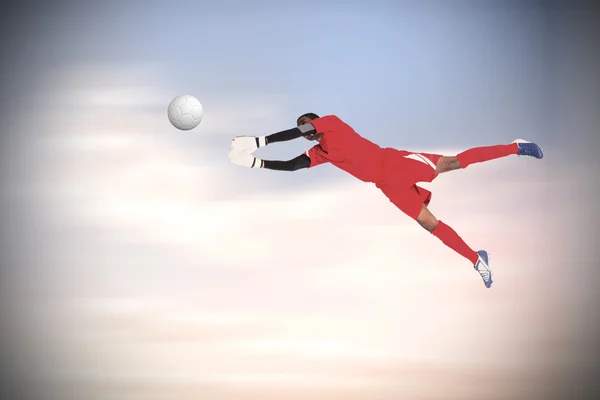 Composite image of goalkeeper in red making a save — Stock Photo, Image