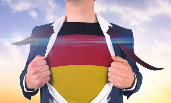 Бизнесмен открывает рубашку, чтобы показать германский флаг — стоковое фото