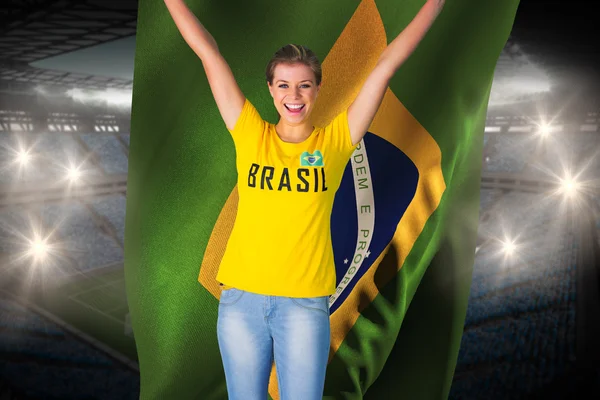 Excited football fan in brasil tshirt holding flag — Stock Photo, Image