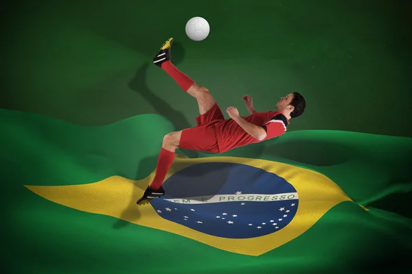 Immagine composita del giocatore di calcio in rosso calci — Foto Stock