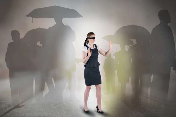 Composite image of redhead businesswoman in a blindfold — Stock Photo, Image