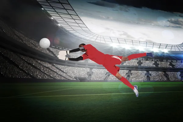 Composite image of goalkeeper in red making a save — Stock Photo, Image