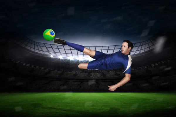 Imagen compuesta de jugador de fútbol en azul patada — Foto de Stock
