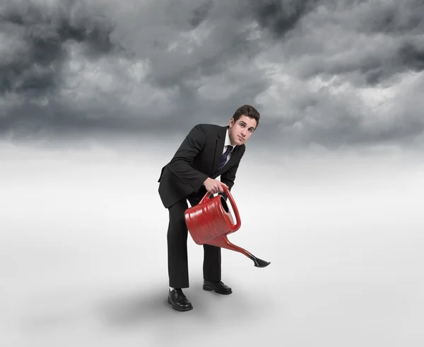 Composite image of businessman watering with red can — Stock Photo, Image