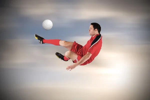 Composite image of football player in red kicking — Stock Photo, Image