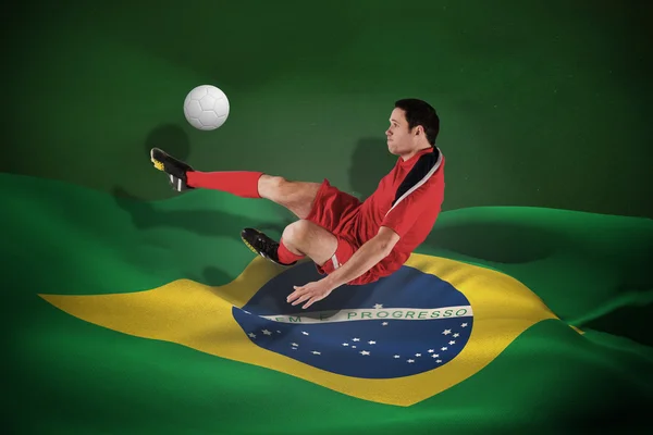 Composite image of football player in red kicking — Stock Photo, Image