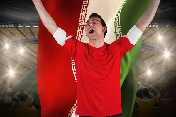 Composite image of excited football fan cheering holding iran fl — Stock Photo, Image