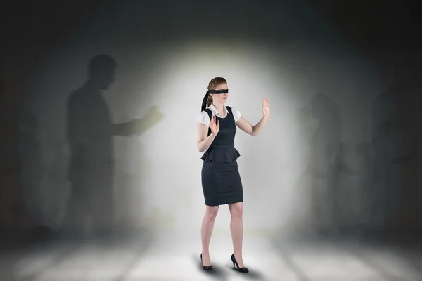 Composite image of redhead businesswoman in a blindfold — Stock Photo, Image