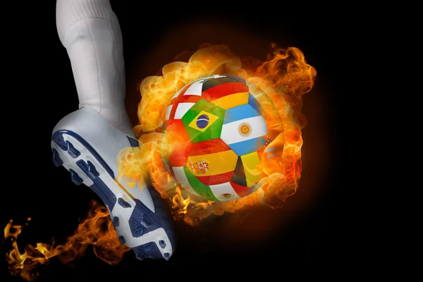 Football player kicking flaming international flag ball — Stock Photo, Image