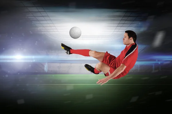 Sammansatt bild av fotbollsspelare i röda sparkar — Stockfoto
