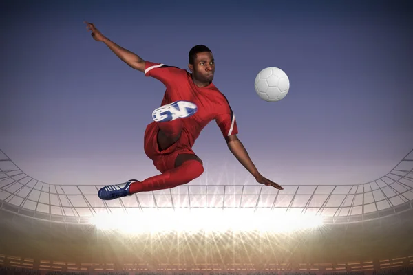 Composite image of football player in red kicking — Stock Photo, Image