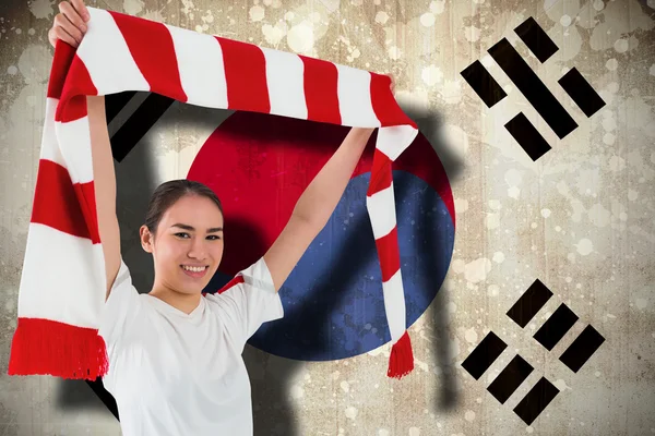 Композитное изображение футбольного болельщика, размахивающего красным и белым шарфом — стоковое фото