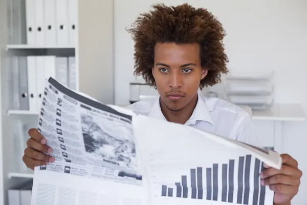 Affärsman läsa tidningen vid skrivbord — Stockfoto