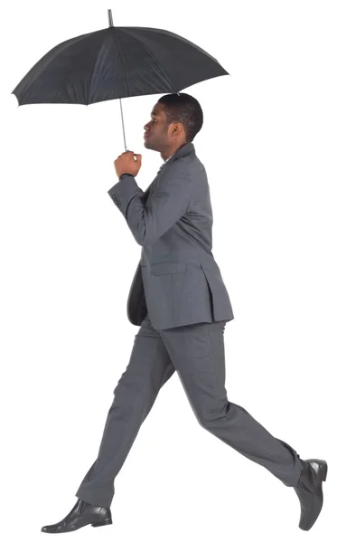 Geschäftsmann geht und hält Regenschirm — Stockfoto