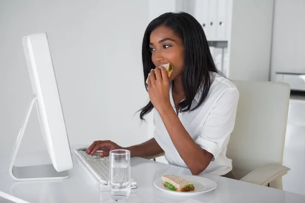 Affärskvinna äter en smörgås — Stockfoto