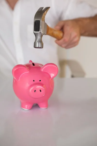 Empresário quebrando porquinho banco com martelo — Fotografia de Stock