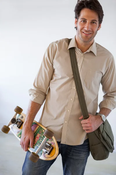 Zakenman permanent met zijn skateboard — Stockfoto