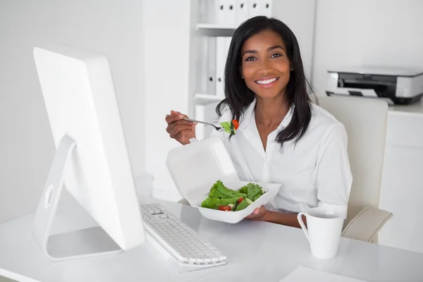 Businesswoman eating a salad at her desk — Stock Photo, Image