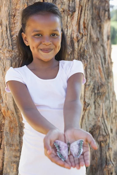 Dívka drží motýl v parku — Stock fotografie
