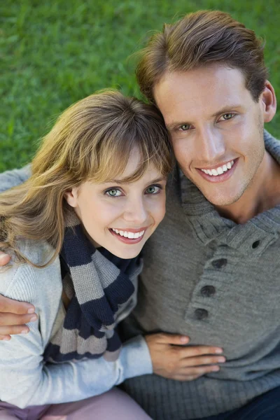 Pareja sentada en el parque abrazando — Foto de Stock