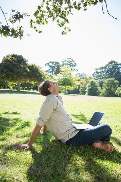 男は公園で彼のラップトップを使用して — ストック写真