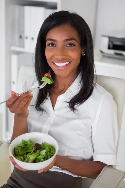 Affärskvinna som äter en sallad på hennes skrivbord — Stockfoto