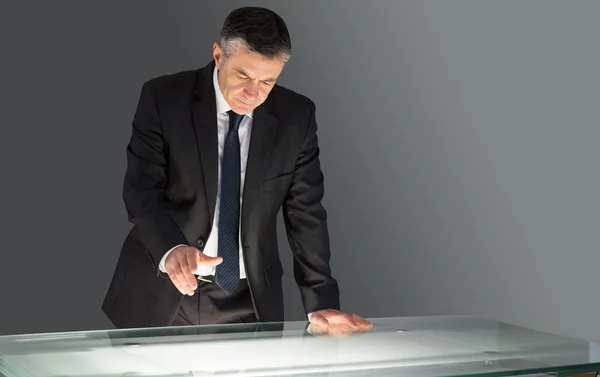 Concentrating businessman leaning on desk — Stock Photo, Image