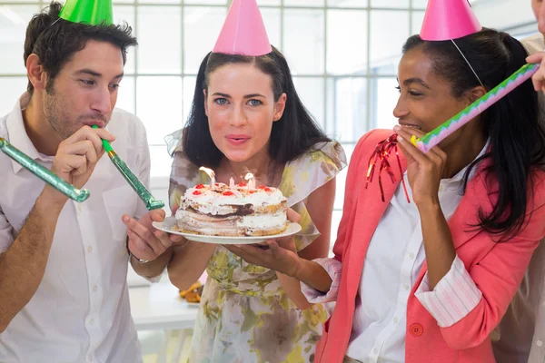 Geschäftsfrau bläst Kerzen auf Kuchen aus — Stockfoto