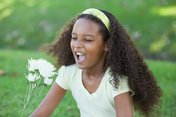 Flicka som håller en blomma i parken — Stockfoto