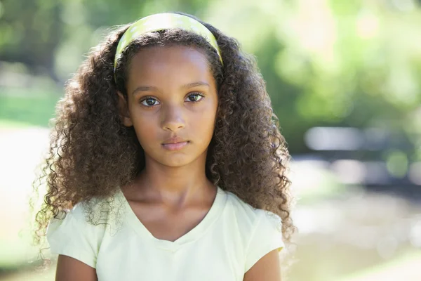 Girl frowning at the camera in the park — Stock Photo, Image