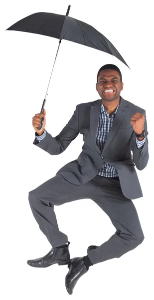 Businessman cheering and holding umbrella — Stock Photo, Image