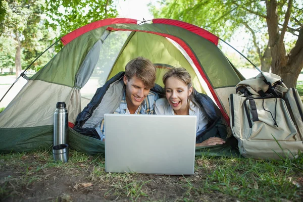 Para leży w swoim namiocie za pomocą laptopa — Zdjęcie stockowe