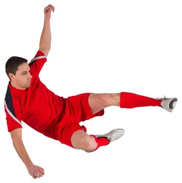 Fit football player jumping and kicking — Stock Photo, Image