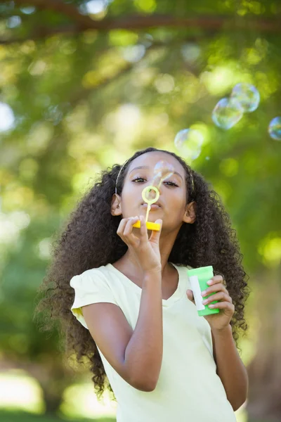 Girl blowing bubbles in the park — Stock Photo, Image