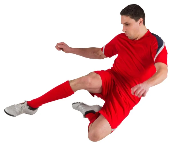 Fit football player jumping and kicking — Stock Photo, Image