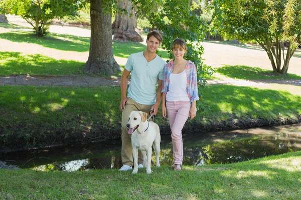 Casal de pé com seu labrador — Fotografia de Stock