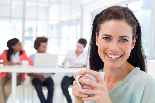 Businesswoman drinking coffee with coworkers — Stock Photo, Image