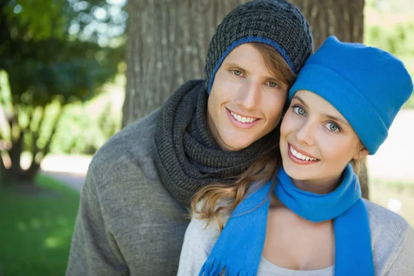 Coppia carina sorridente alla fotocamera in cappelli e sciarpe — Foto Stock