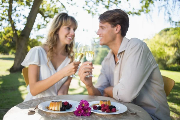 Paar stößt draußen mit Champagner an — Stockfoto